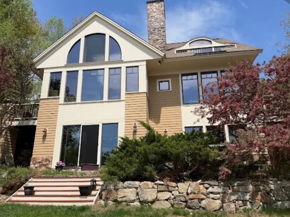 A lakeside home with a two-story arched window wall, cleaned inside and out