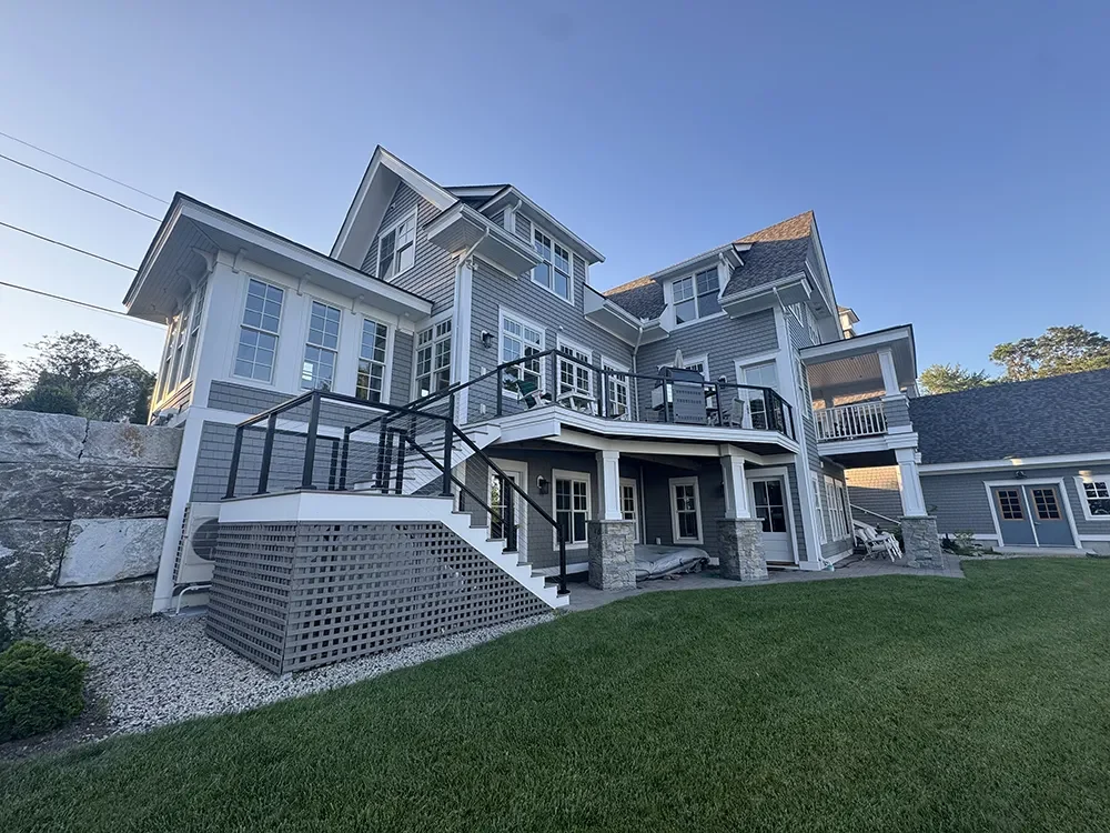 A large shingled home with multiple gables and decks, windows cleaned