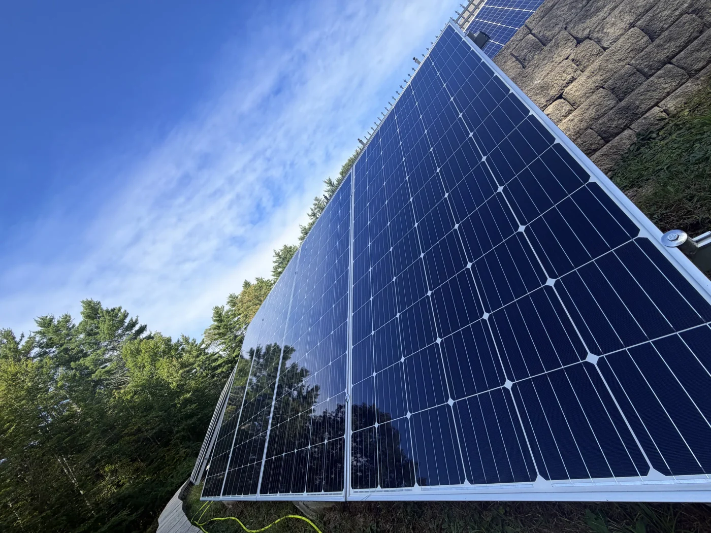 Looking up the face of a freshly cleaned solar panel with open sky reflected in the glass