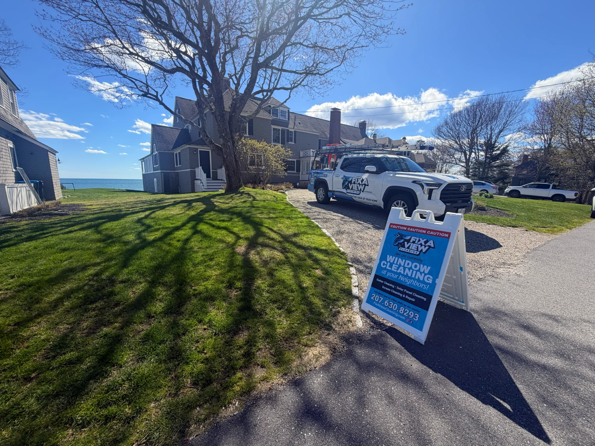 The Fix A View truck and sign at an oceanfront property in Maine